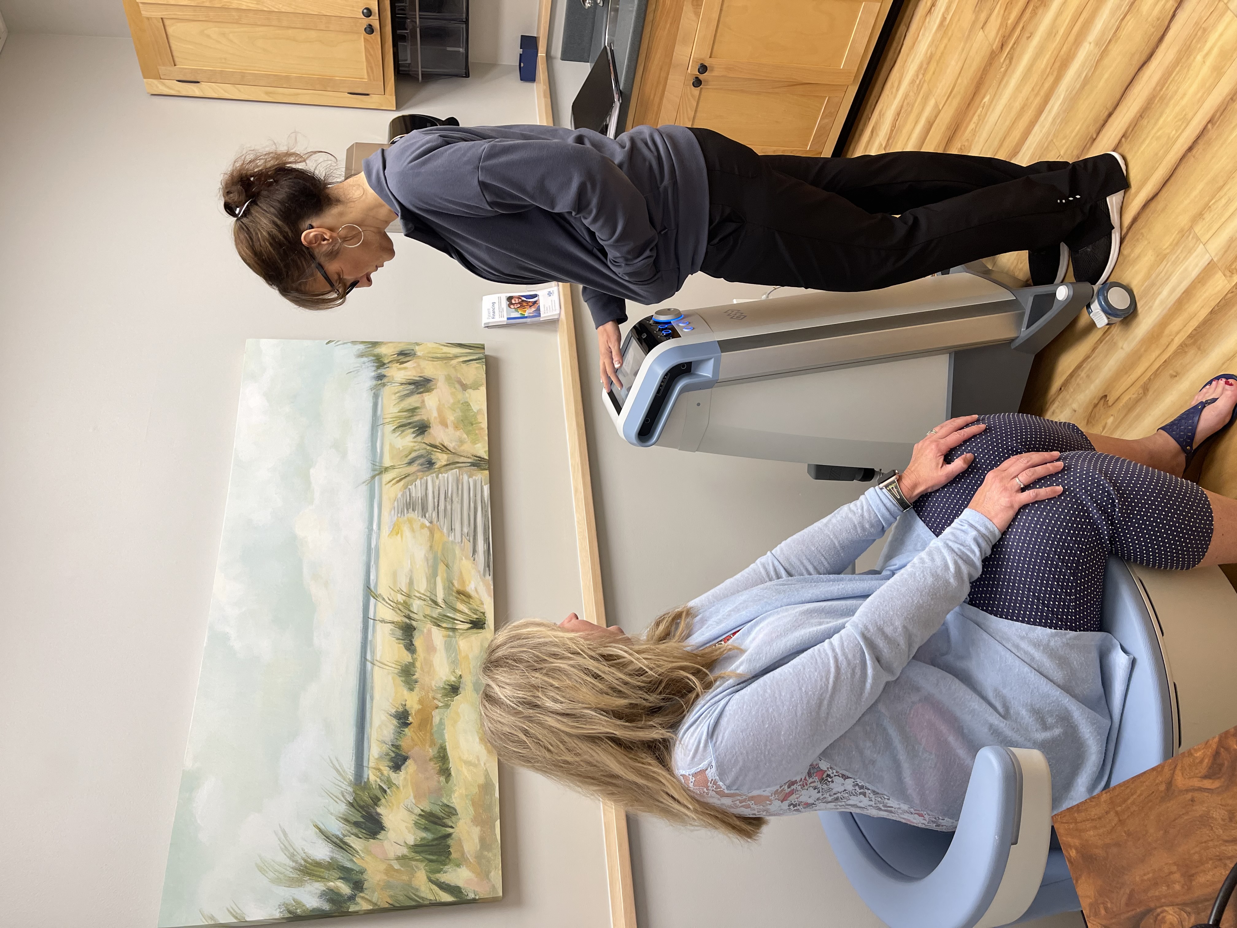 doctor carmichael demonstrating how the emsella machine is used in her office.